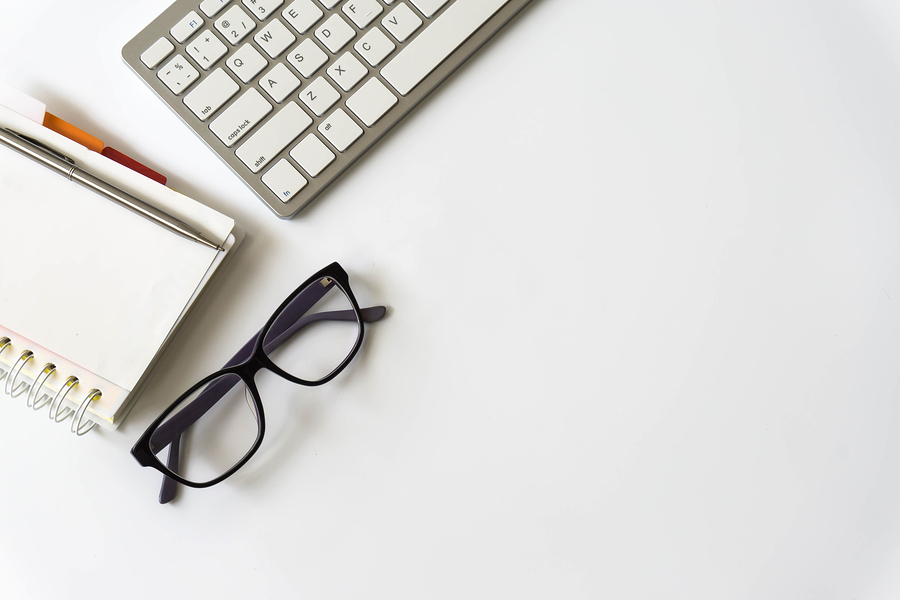 Glasses, note pad and keyboard